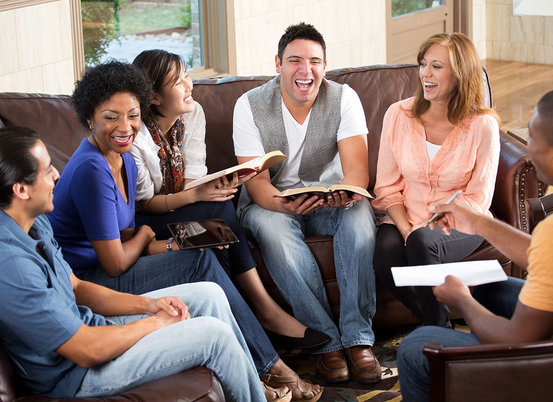 Read Our Reviews - Cheerful Group of Diverse Adults Having Fun Sitting Togerther During a Bible Study Session at Church